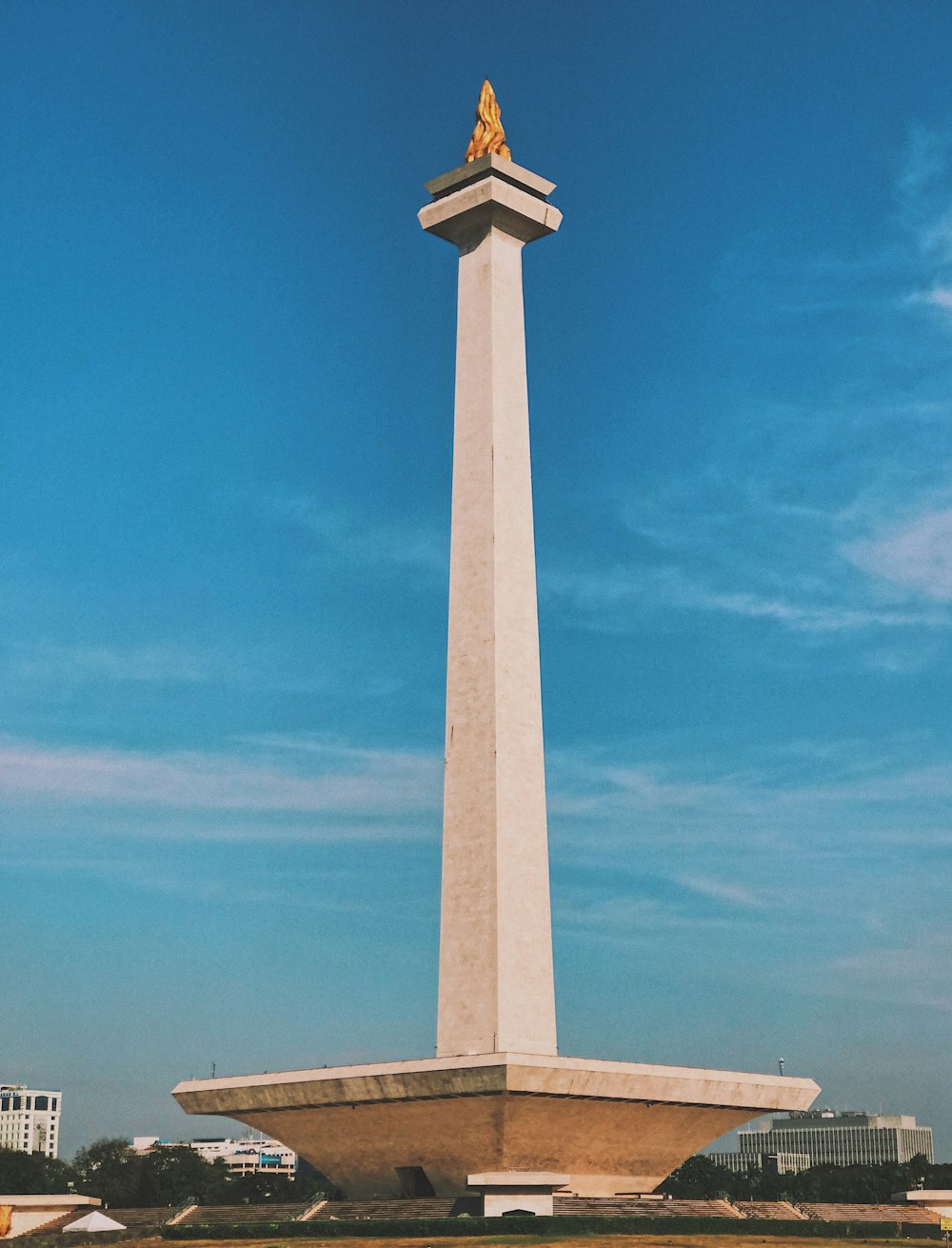 a tall white monument with a gold statue on top of it