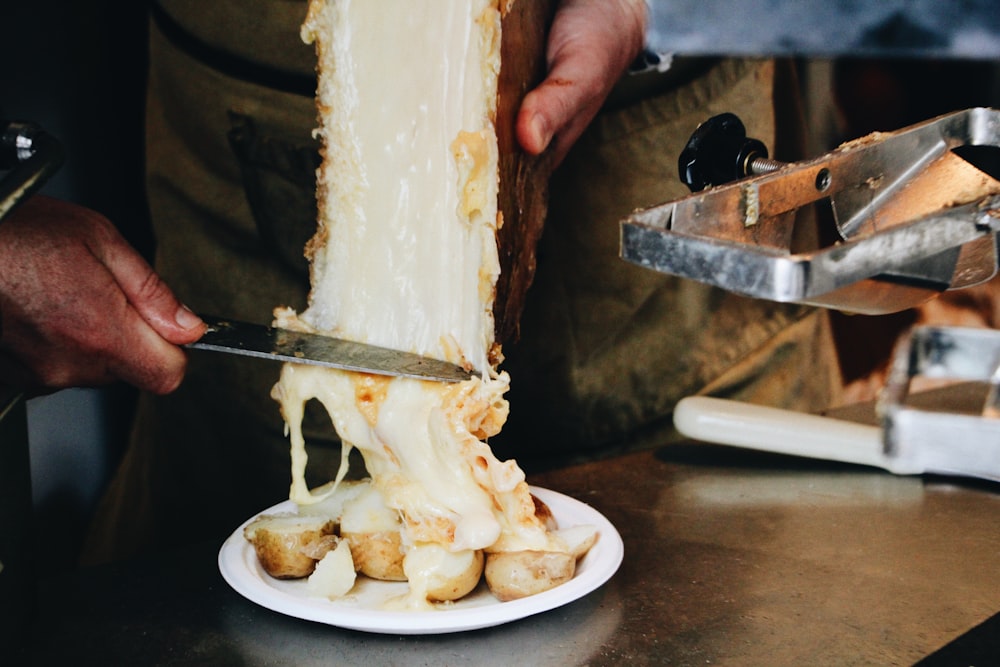 a person cutting a piece of cake with a knife