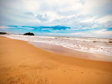 a sandy beach with waves coming in to shore