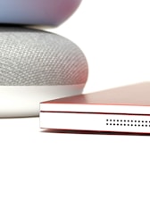 Close-up of an Alexa device with the Lazus Anime Radio logo on a smartphone screen nearby.