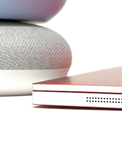 A close-up of a smart speaker and a home automation device.