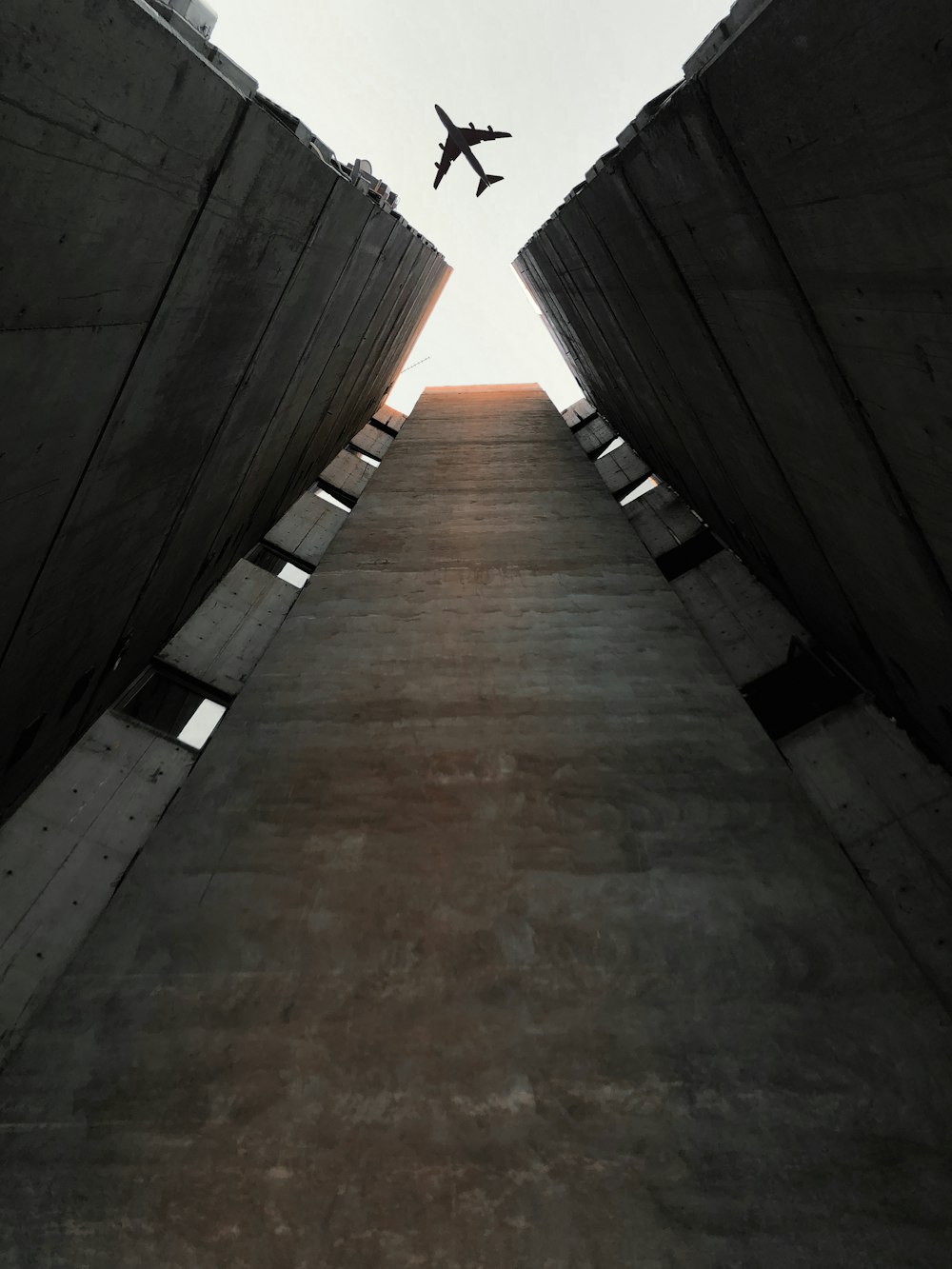 an airplane is flying over a concrete structure