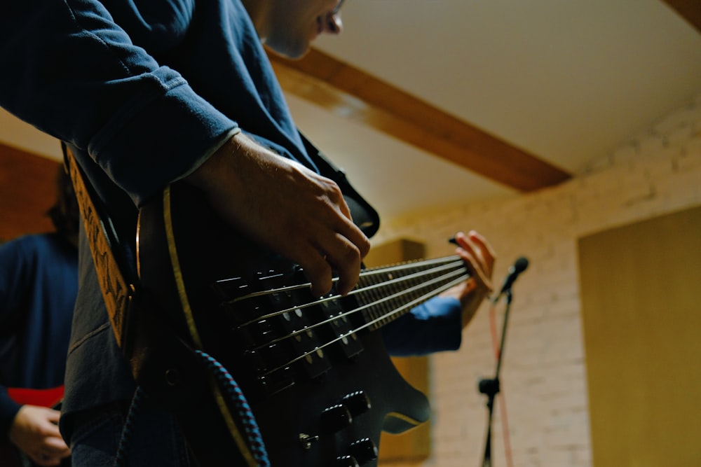 a man playing a guitar in front of a microphone