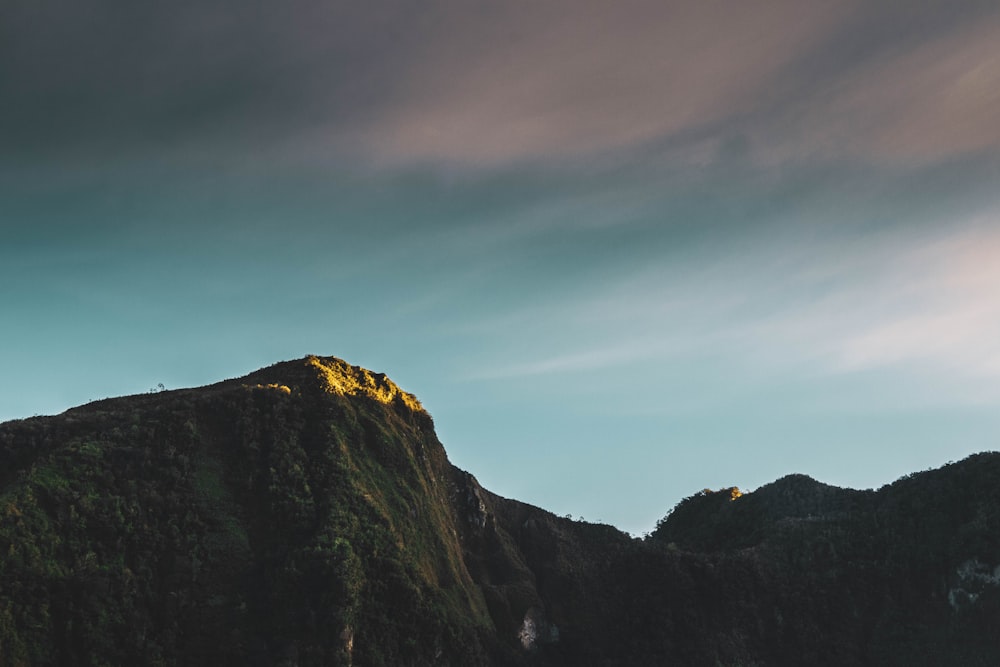 a very tall mountain with a sky in the background