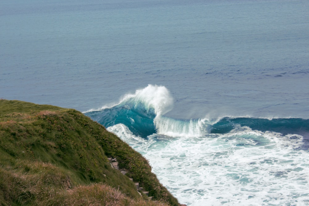 a large wave crashing into the shore of the ocean