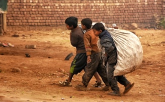 a group of young boys walking down a dirt road