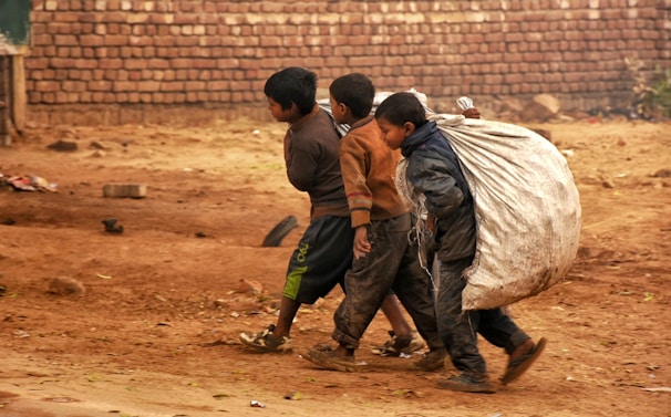 a group of young boys walking down a dirt road