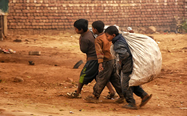 a group of young boys walking down a dirt road