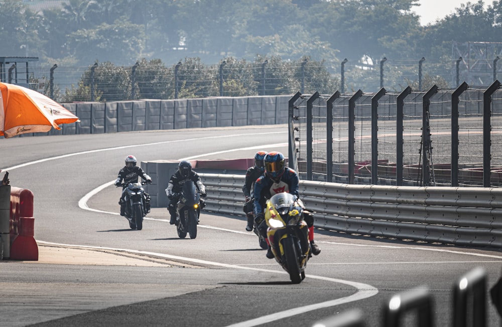 a group of people riding motorcycles on a race track