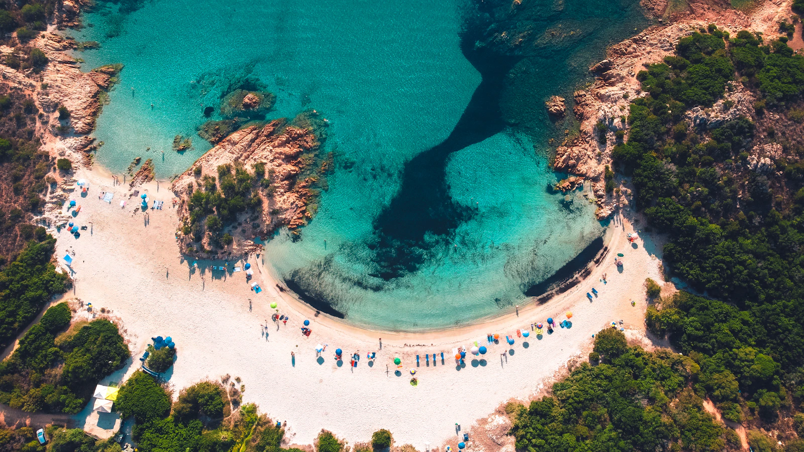 Aerial view of a white sand cove and turquoise water in Sardinia