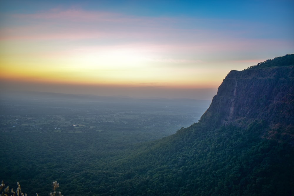 a view of a mountain with a sunset in the background