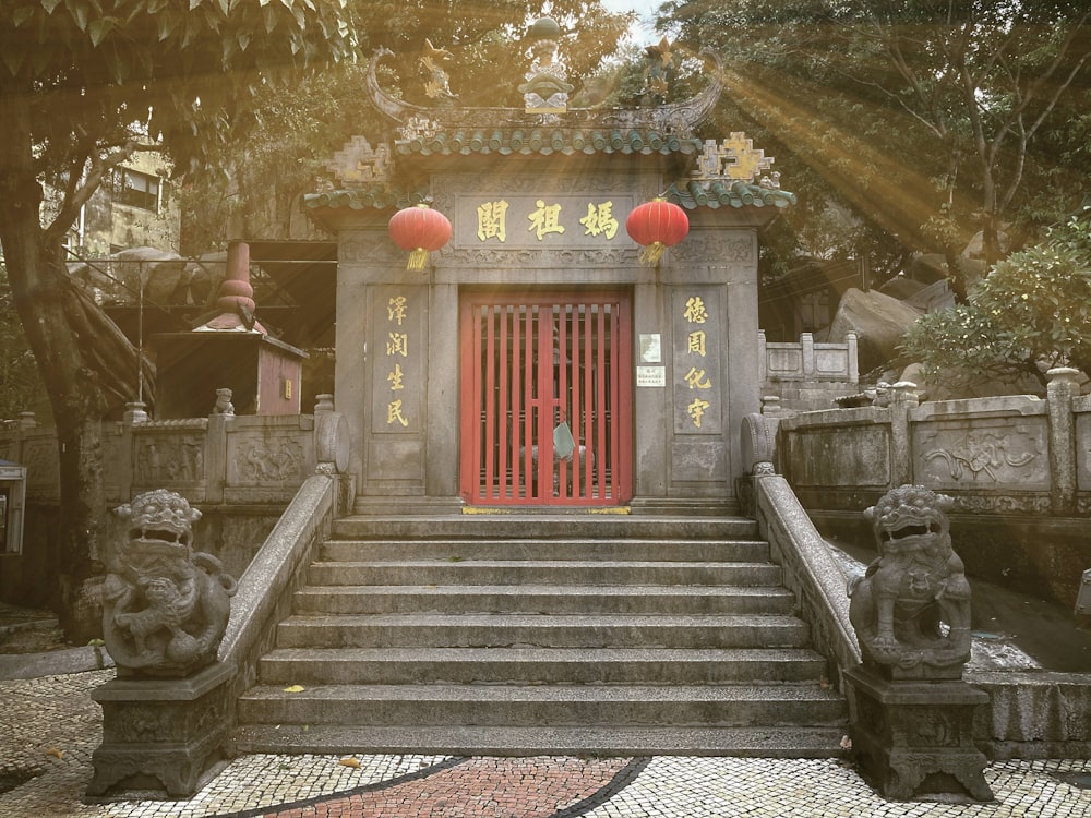 a chinese temple with a red door surrounded by stone statues