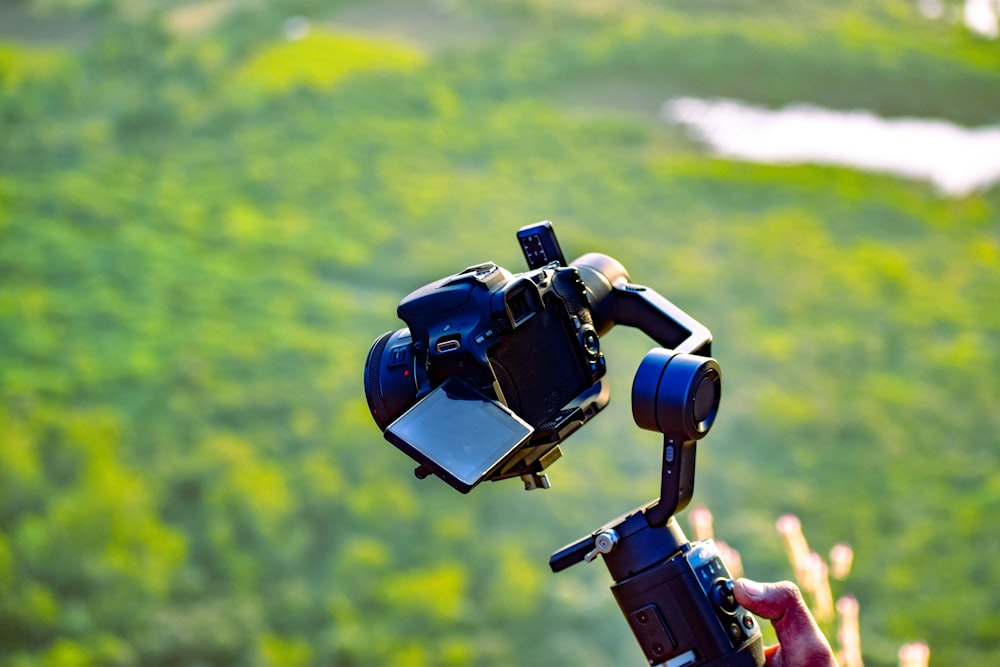 a person holding a camera up in the air