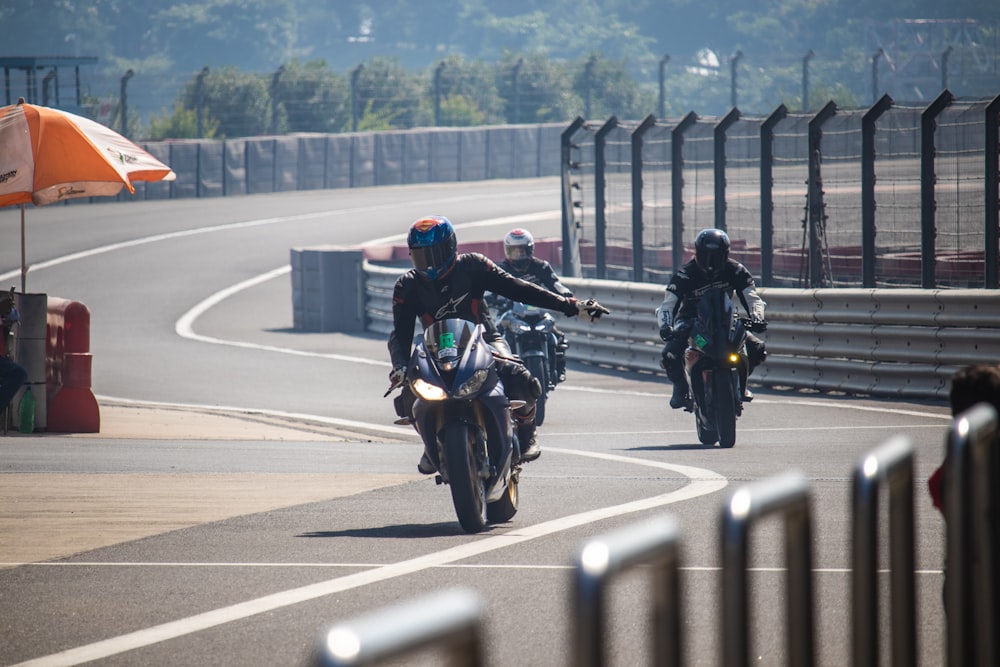 two people riding motorcycles on a race track