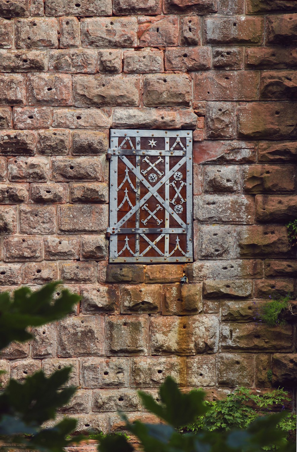 a brick wall with a metal window on it