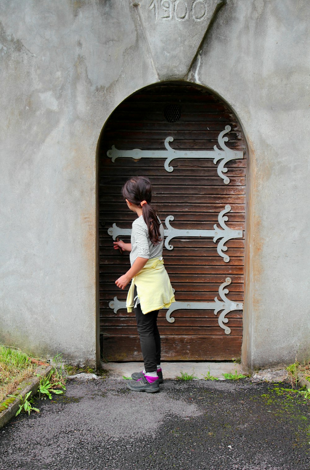 a little girl standing in front of a garage door