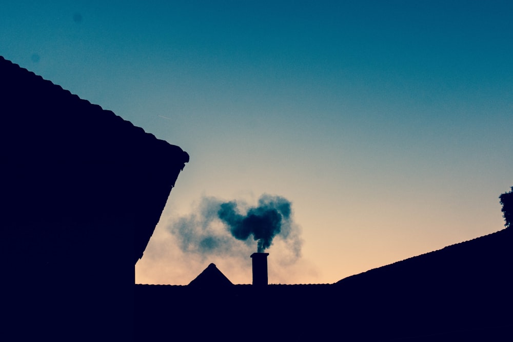 a smokestack emits from the roof of a building