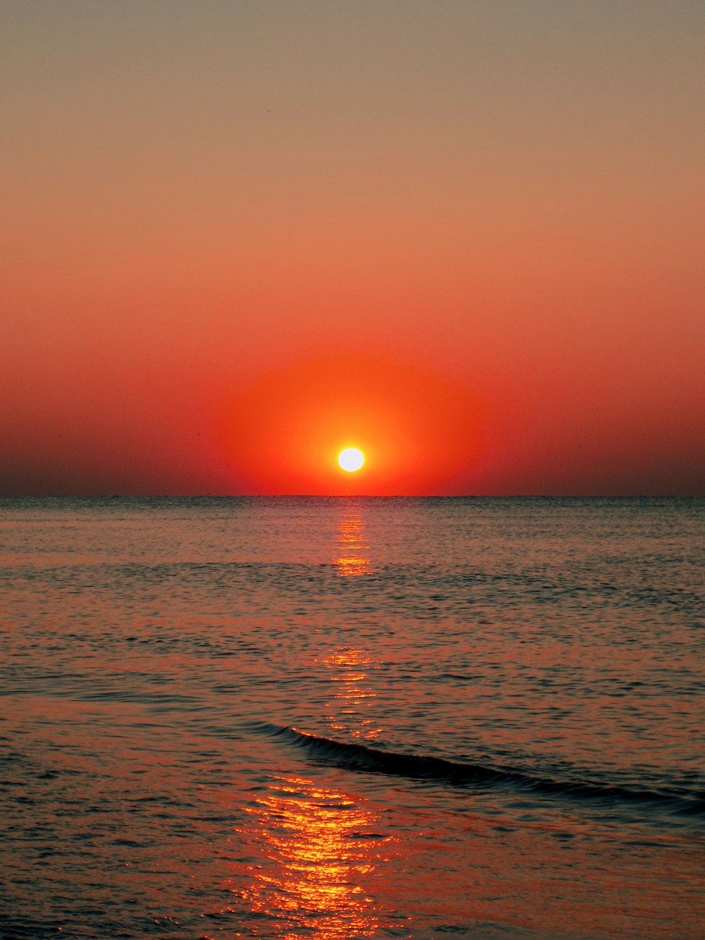 the sun is setting over the ocean on a clear day