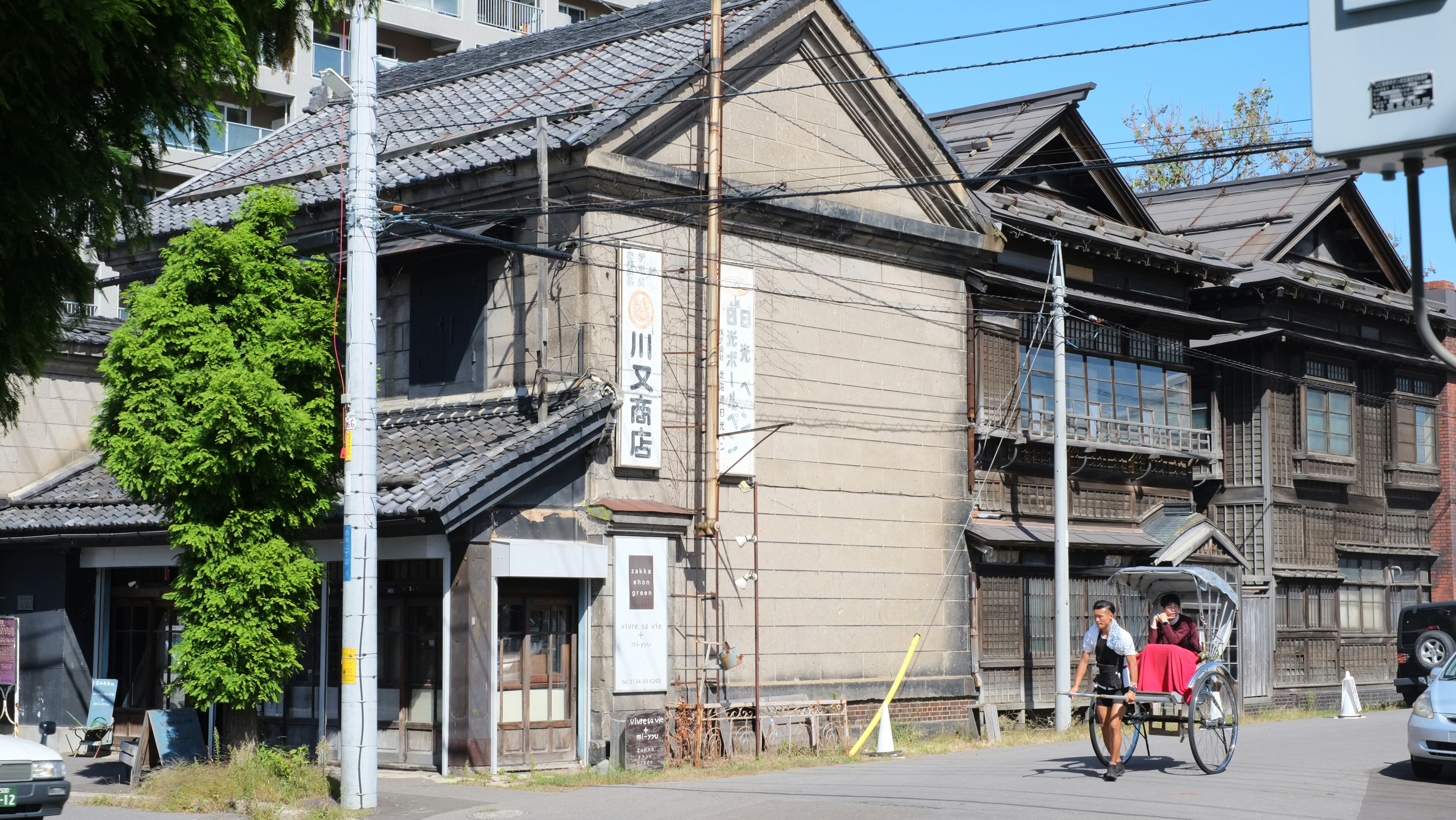 a man riding a bike down a street next to a tall building