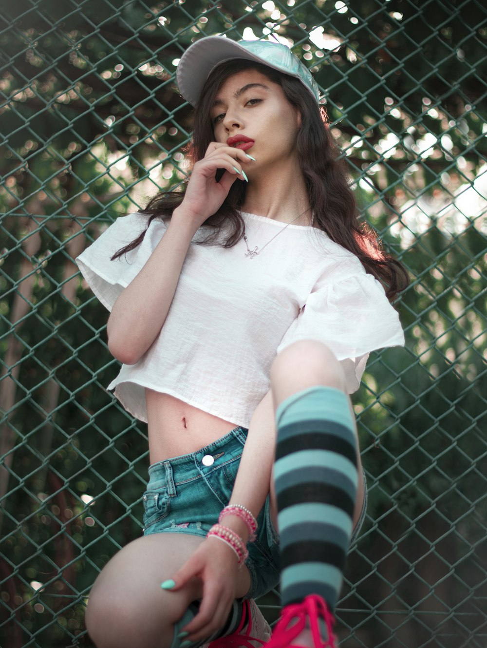 a woman with a hat and striped socks smoking a cigarette