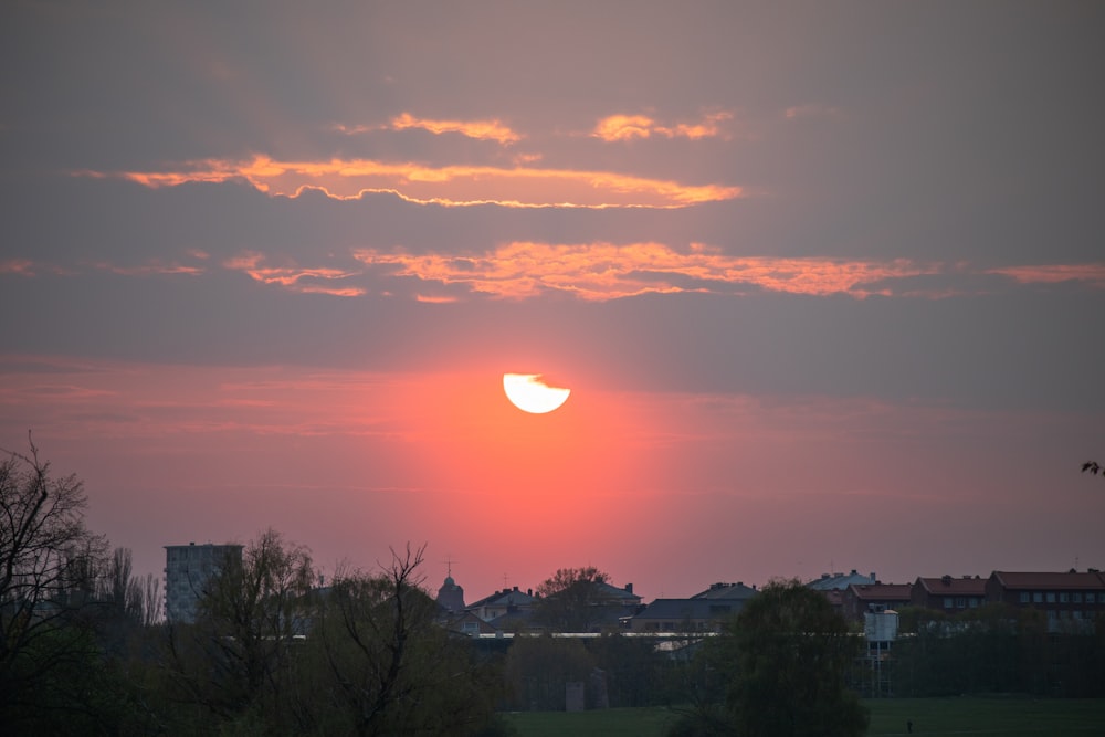 the sun is setting in the sky over a city