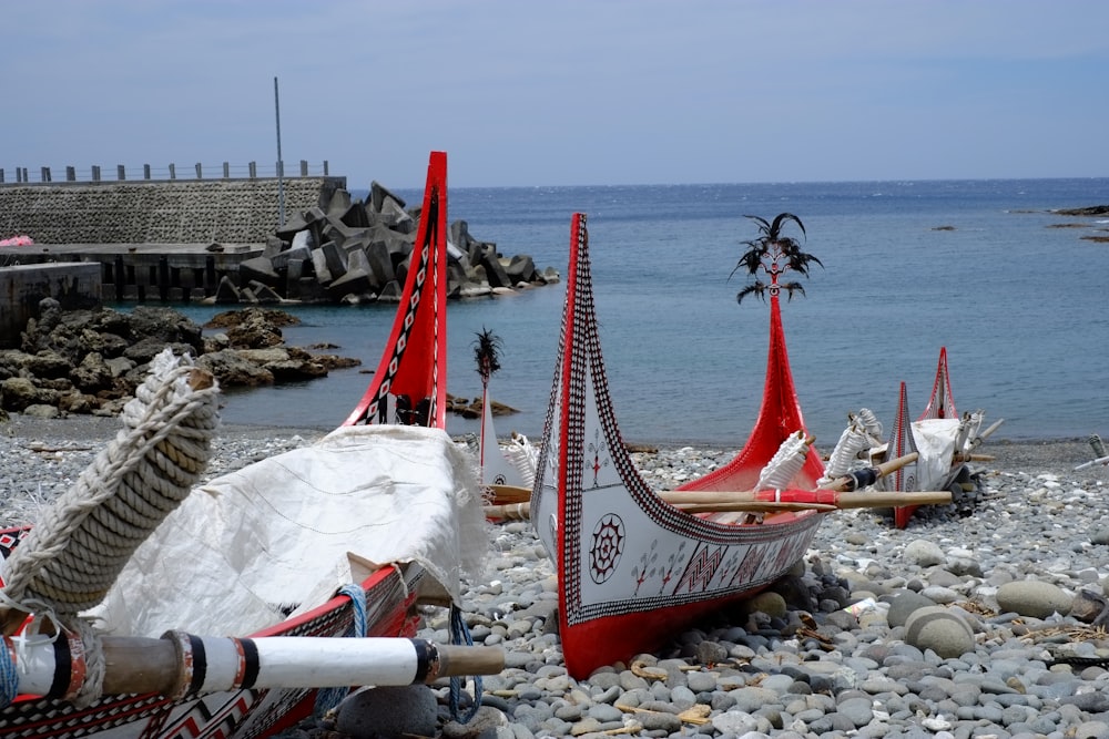 a row of boats sitting on top of a rocky beach