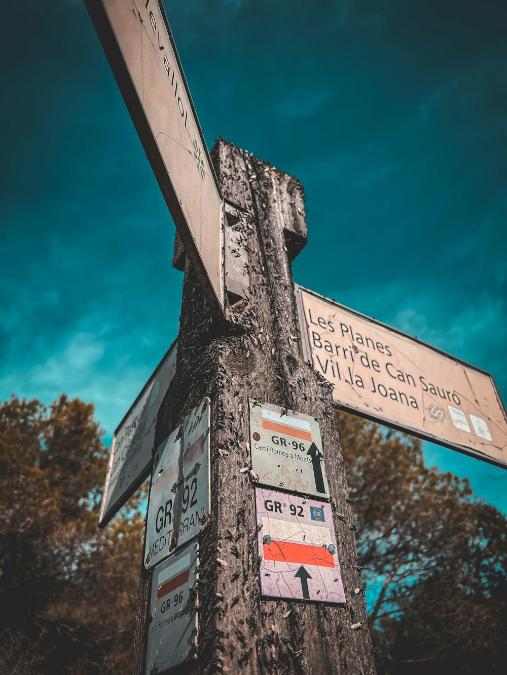 a wooden pole with street signs attached to it