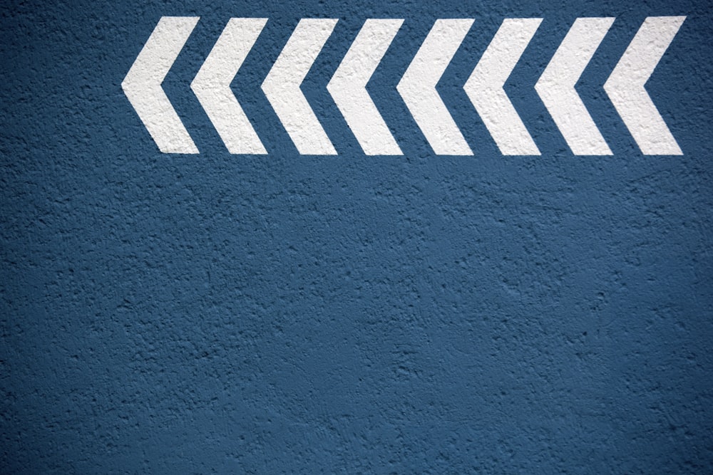 a blue wall with a white arrow painted on it