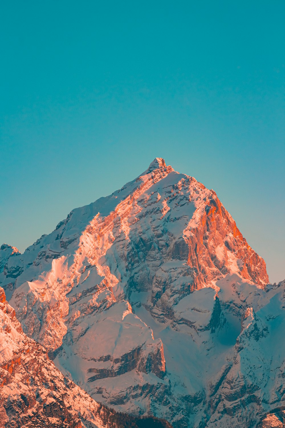 Una montaña cubierta de nieve con un cielo azul en el fondo