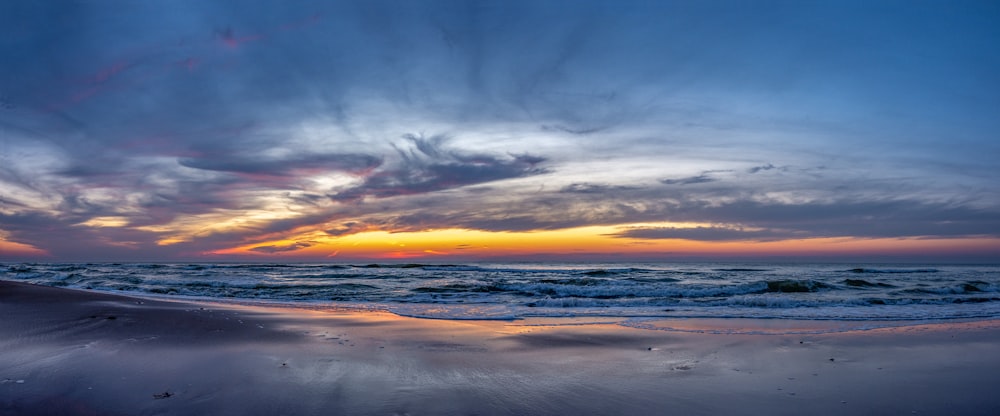 the sun is setting over the ocean on the beach