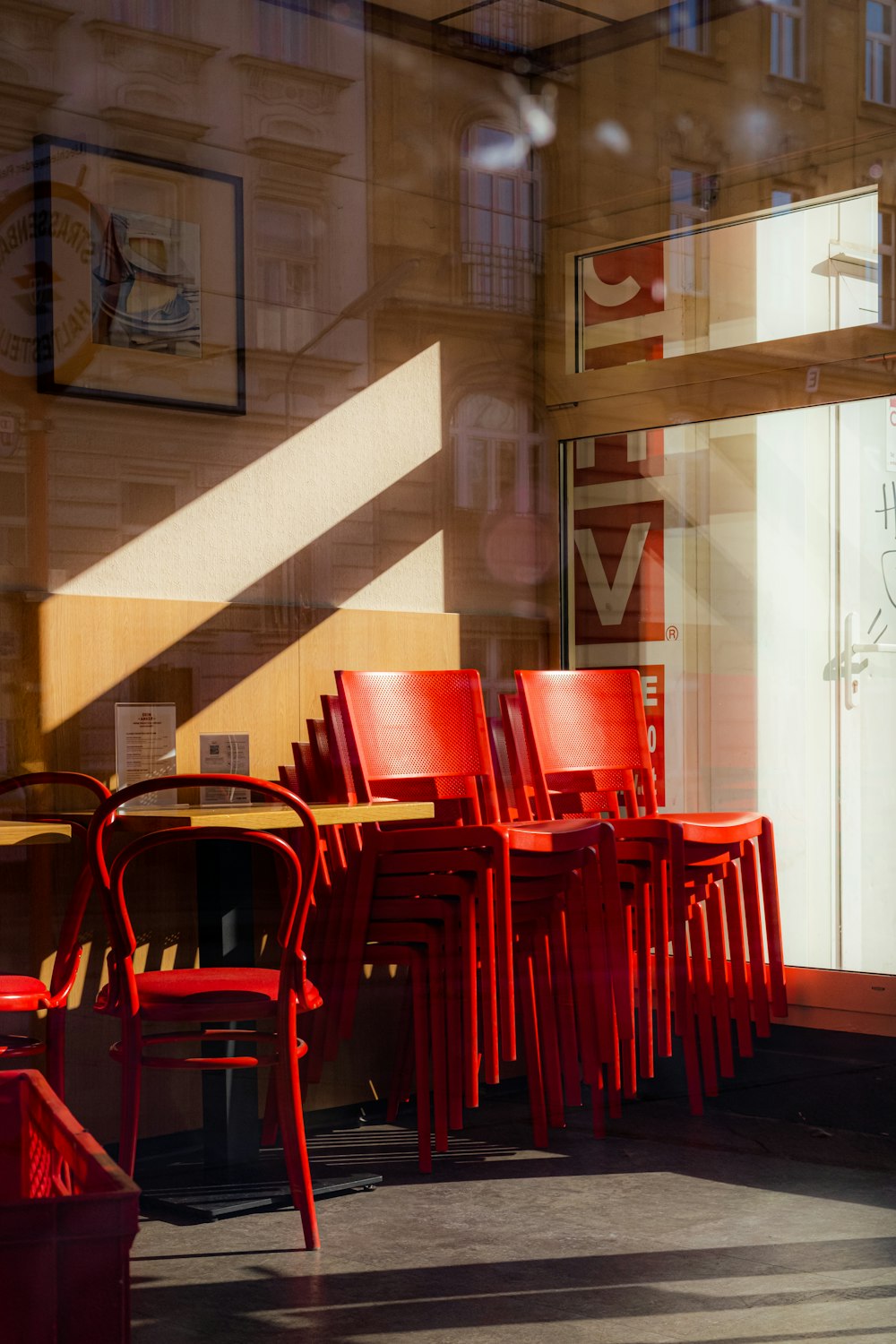 a row of red chairs sitting in front of a window