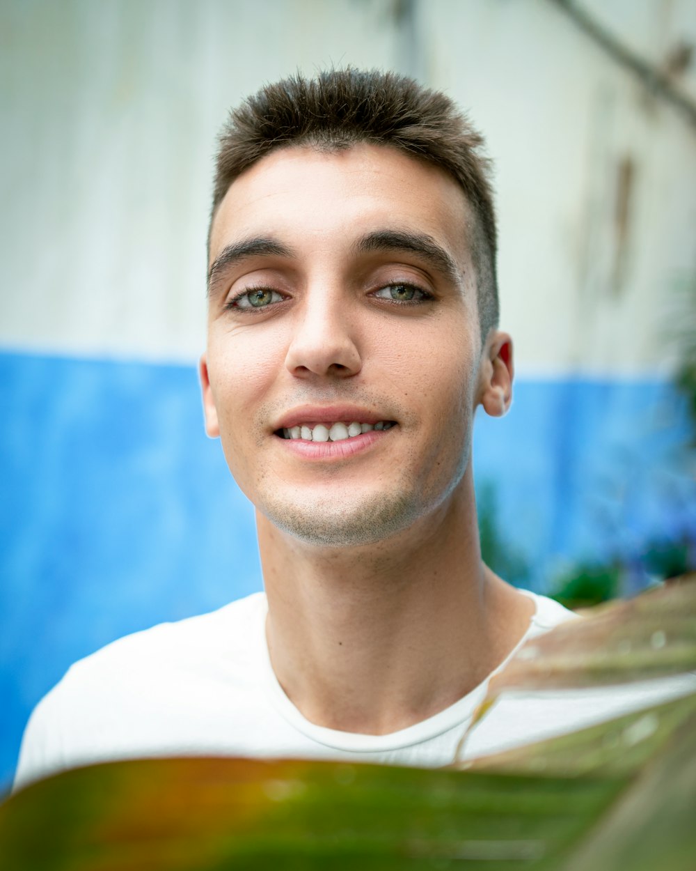 a man with a white shirt is smiling for the camera