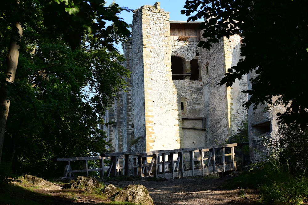 a stone building with a wooden fence in front of it