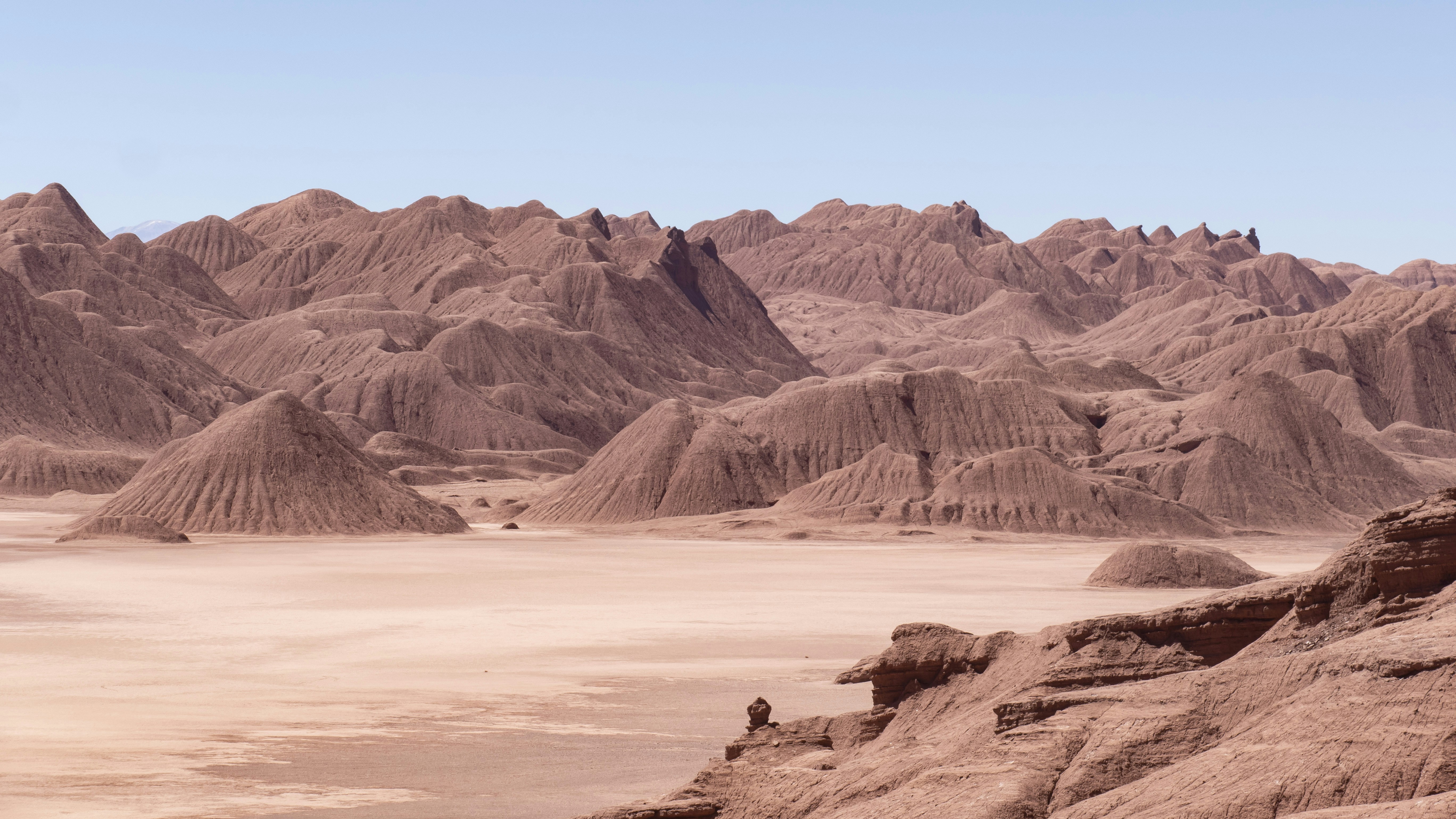 a man standing on top of a mountain next to a desert