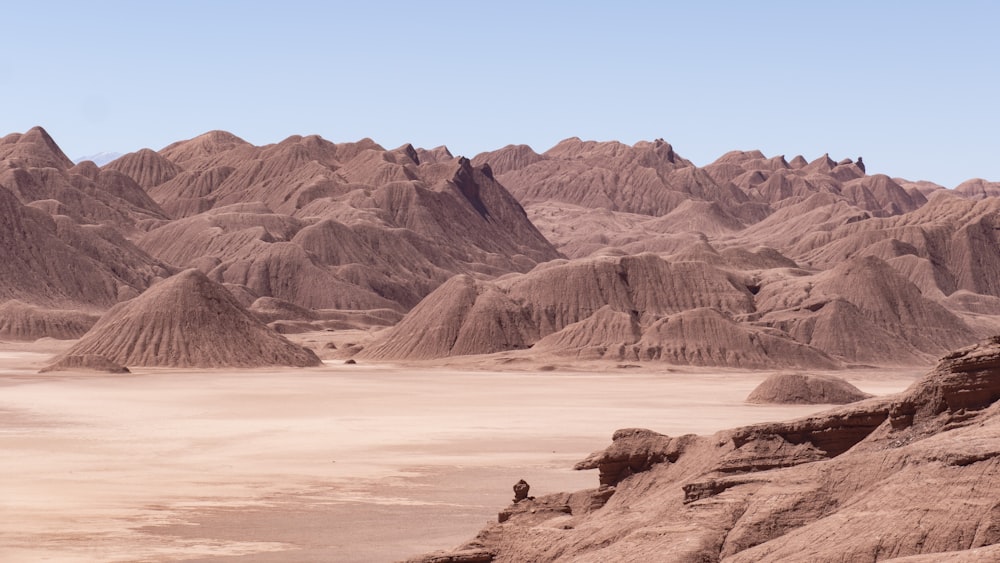 a man standing on top of a mountain next to a desert