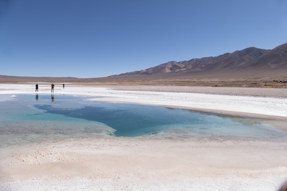 a couple of people walking across a large body of water