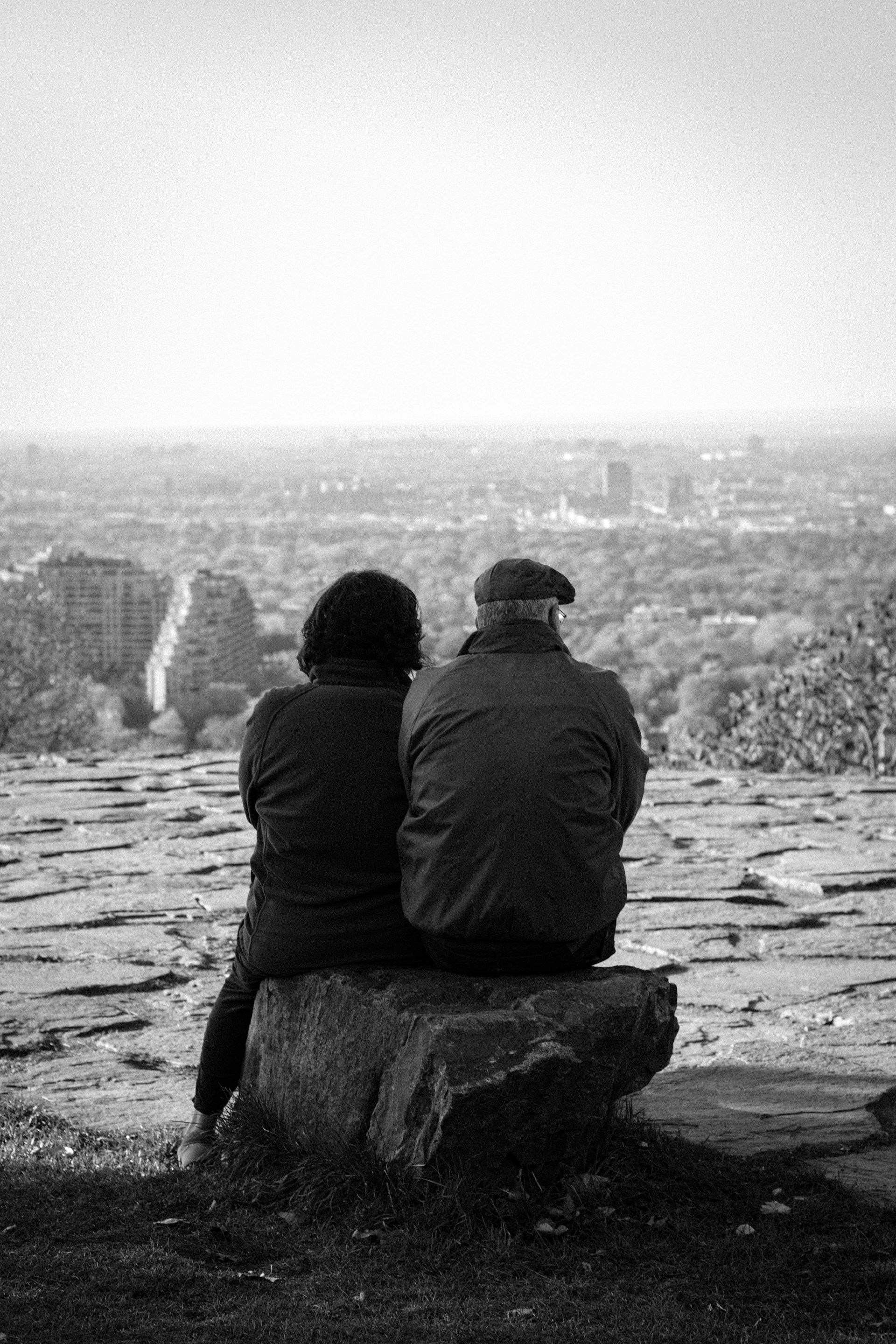 a couple of people sitting on top of a rock