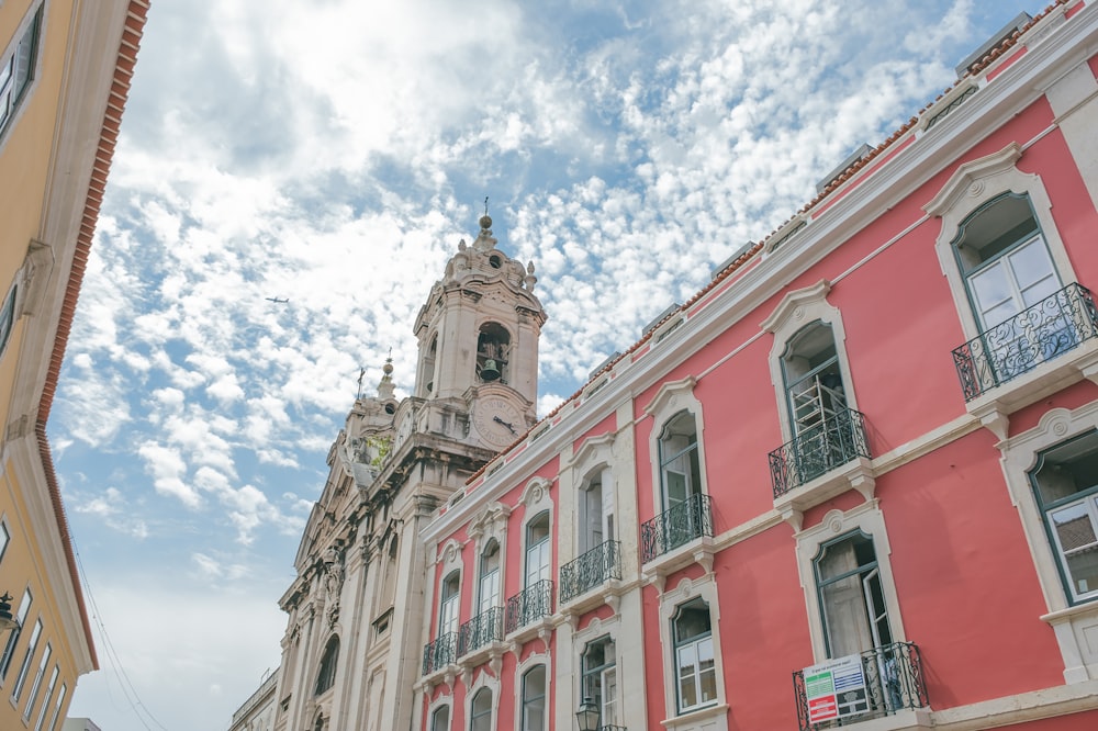 a tall building with a clock tower next to other buildings