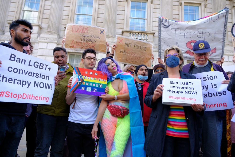 a group of people holding signs in front of a building