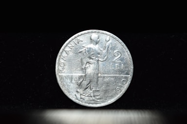 macro photography,how to photograph romanian old coin from 1910; a close up of a coin on a table