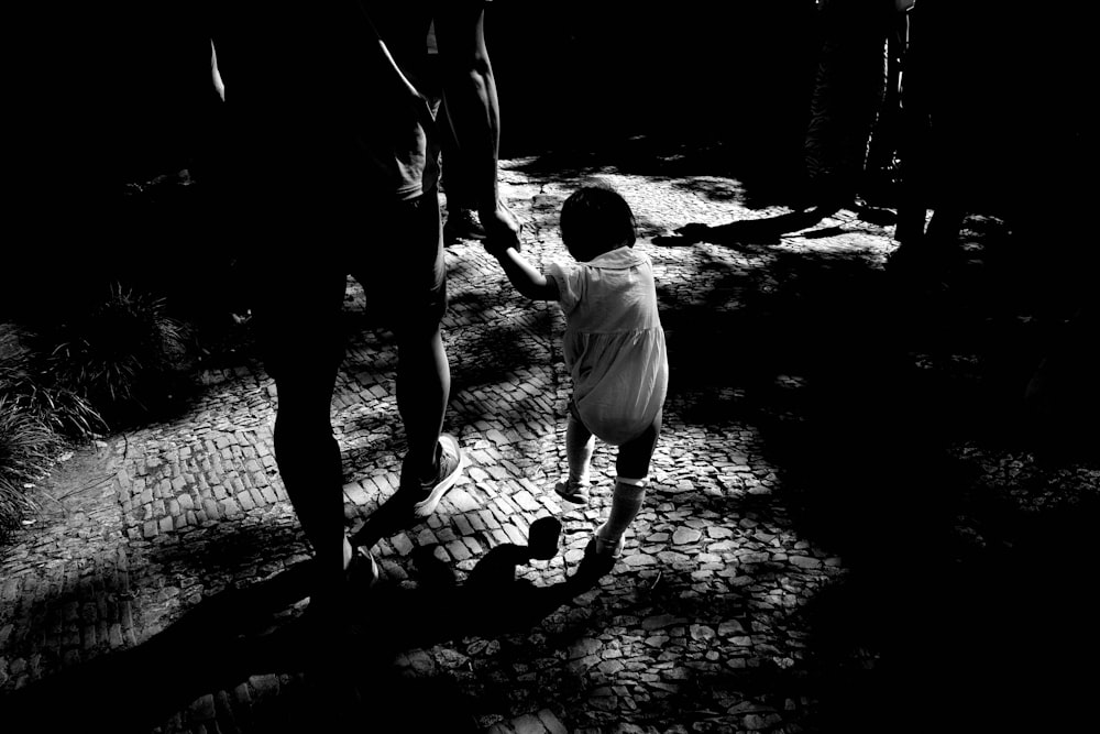 um homem e uma criança estão andando no escuro