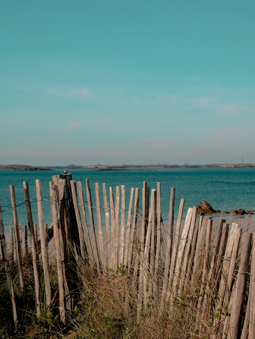 a wooden fence next to a body of water