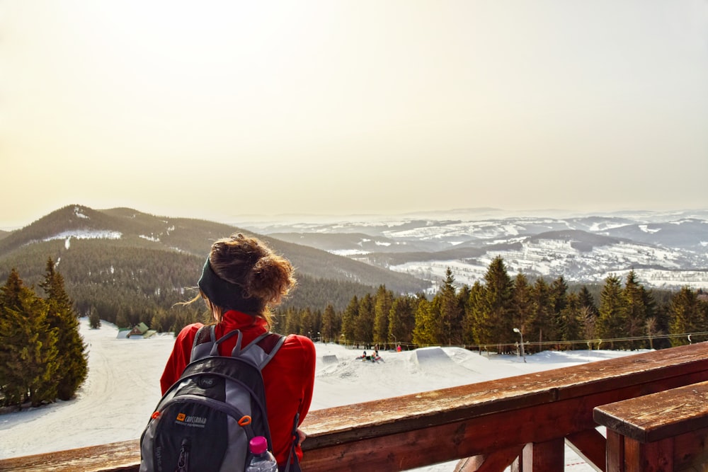 a woman standing on top of a snow covered slope