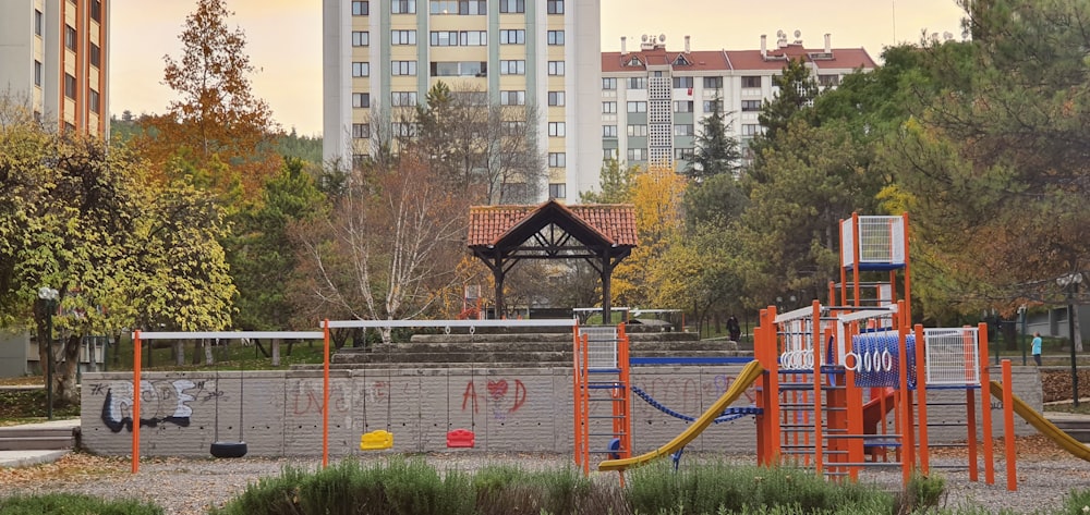 a playground in a park with a building in the background