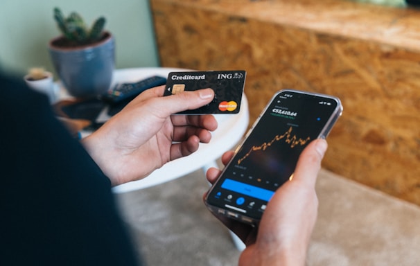 a person holding a smart phone and a credit card