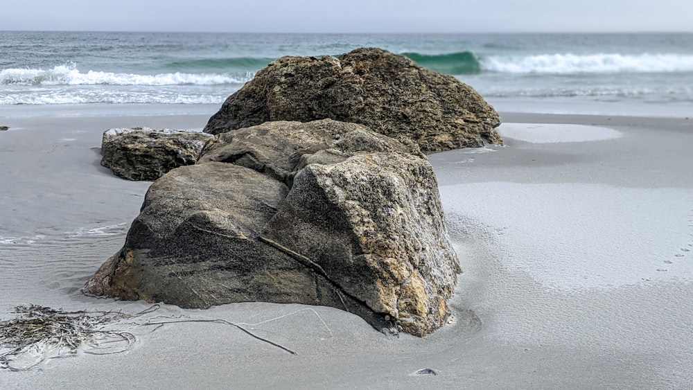 a large rock sitting on top of a sandy beach