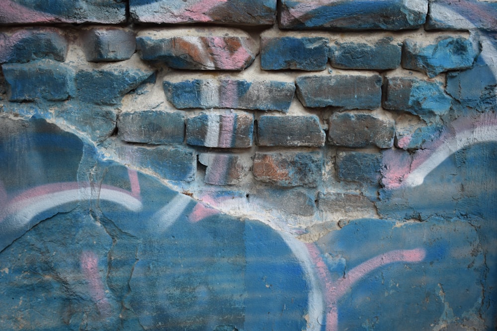 a blue brick wall with graffiti on it