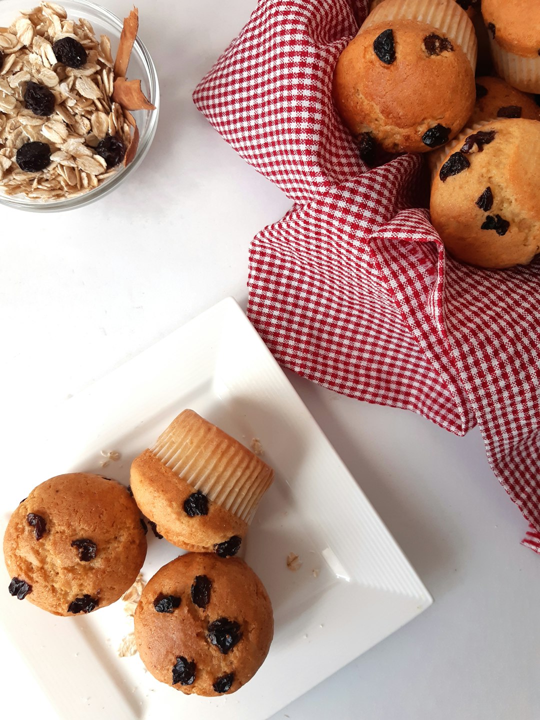 a white plate topped with muffins next to a bowl of oatme