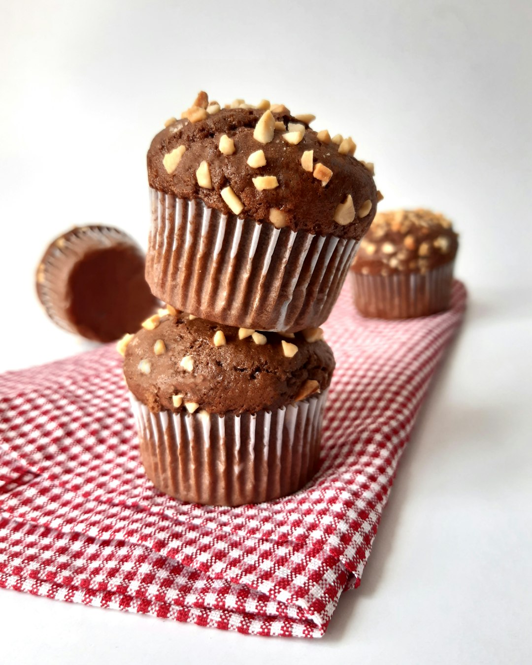 a stack of chocolate muffins sitting on top of a red and white check