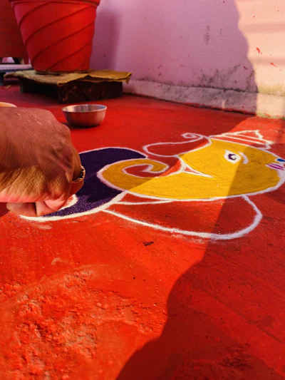 A close-up of hands gently shaping colorful mandala patterns with natural pigments